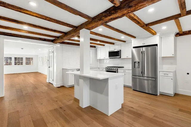 a kitchen with stainless steel appliances a refrigerator and wooden floor