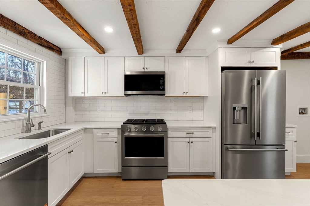 34 Central Street, Unit 1 Rowley, MA 01969 - Photo 7 of 27 a kitchen with stainless steel appliances a refrigerator stove and sink
