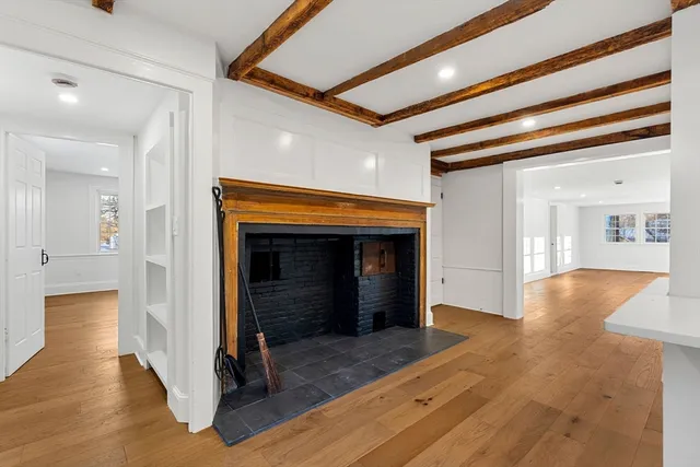 a view of a hallway with wooden floor and a living room