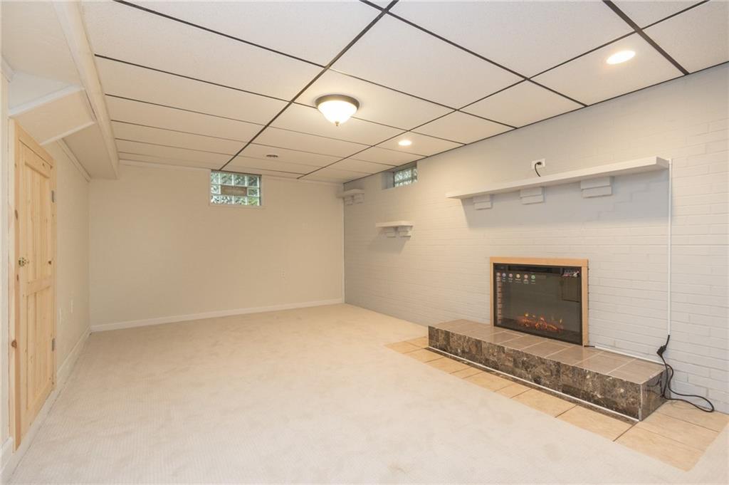 1153 Pentland Avenue Rochester, PA 15074 - Photo 15 of 23 Lower level family room with new carpet, full wall brick fire place with new electric insert, barn door, light fixtures, and freshly painted.