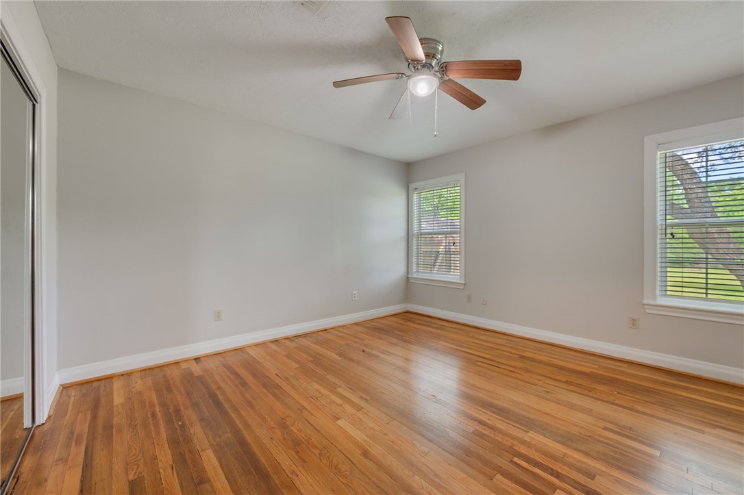 715 Inwood Drive Bryan, TX 77802 - Photo 28 of 34 an empty room with wooden floor and windows