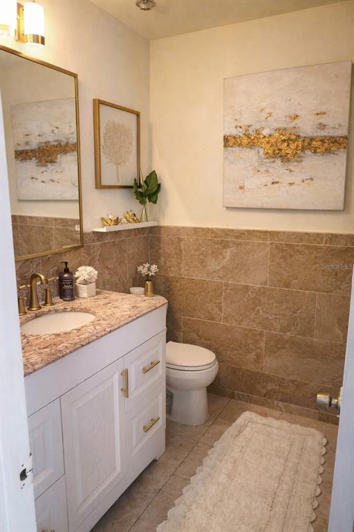 2237 Viento Street Orlando, FL 32822 - Photo 11 of 14 a bathroom with a granite countertop sink a toilet and a mirror