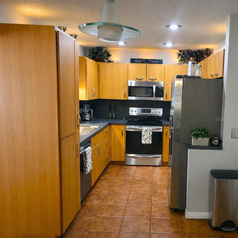 2237 Viento Street Orlando, FL 32822 - Photo 7 of 14 a kitchen with stainless steel appliances granite countertop a refrigerator a stove and a sink