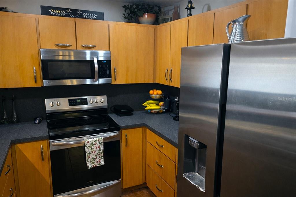 2237 Viento Street Orlando, FL 32822 - Photo 8 of 14 a kitchen with stainless steel appliances a stove a microwave and a refrigerator