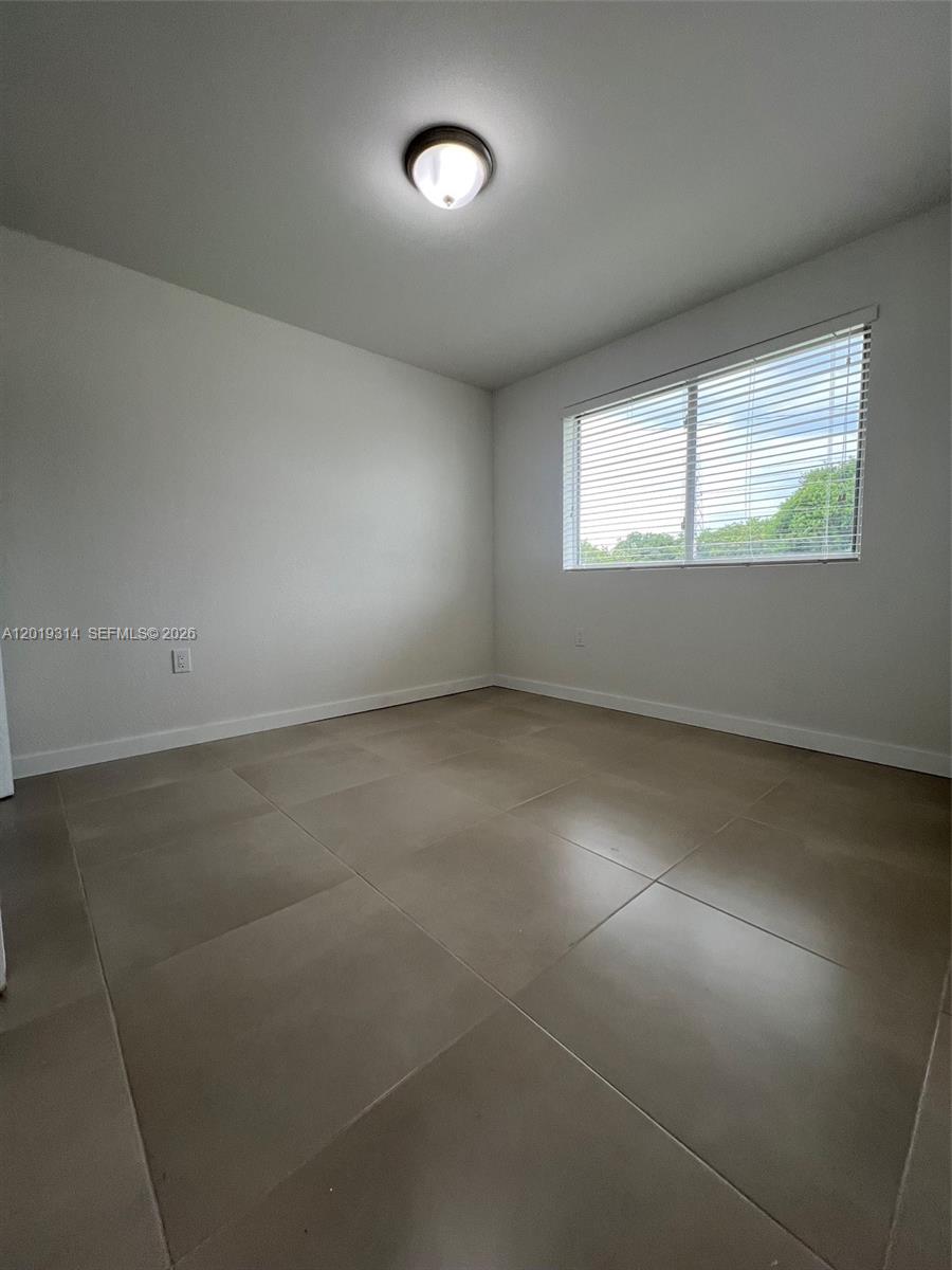 199 Redland Road, Unit B5 Florida City, FL 33034 - Photo 13 of 15 an empty room with a empty space and windows