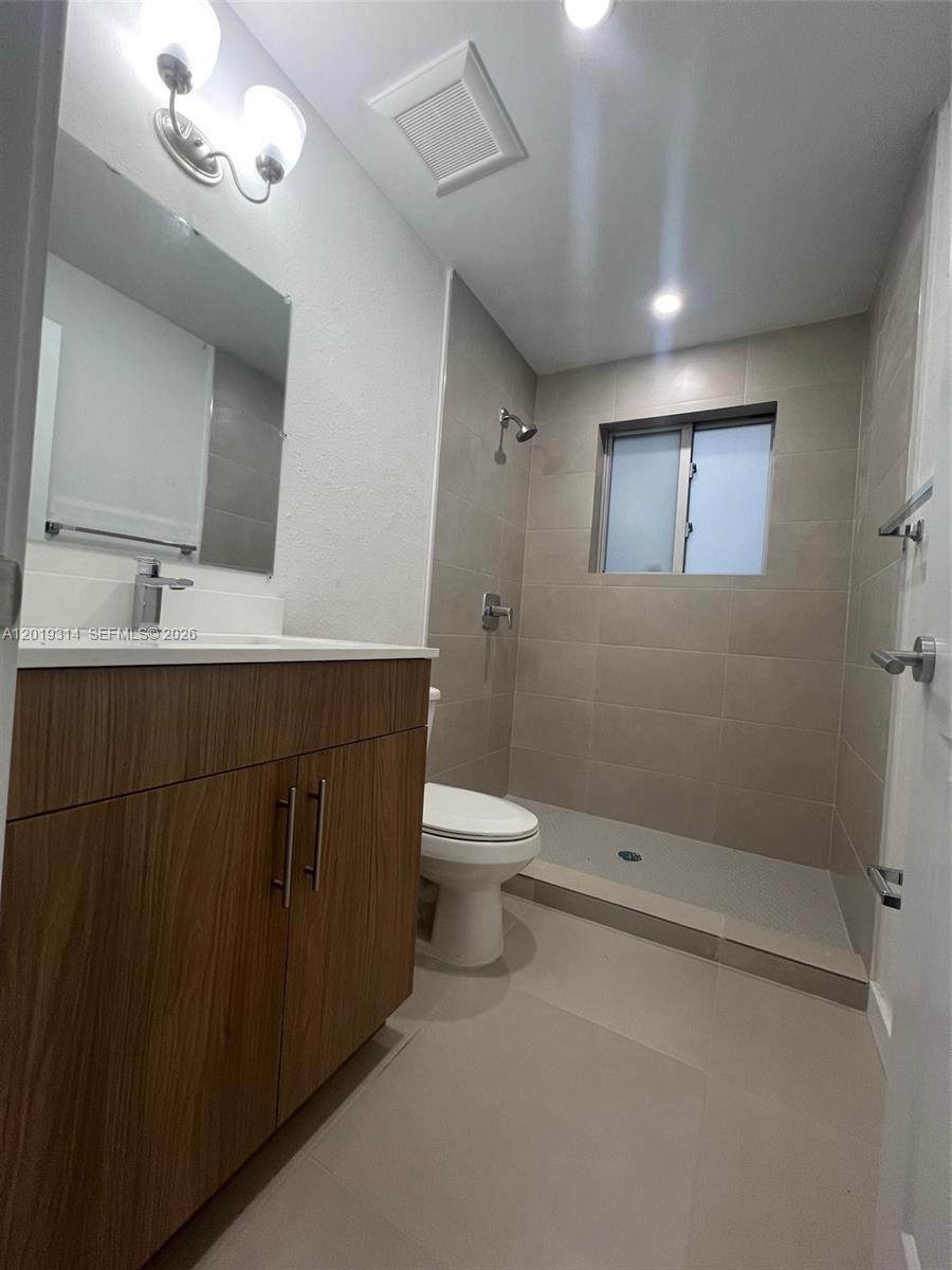 199 Redland Road, Unit B5 Florida City, FL 33034 - Photo 15 of 15 a bathroom with a toilet sink a mirror and shower