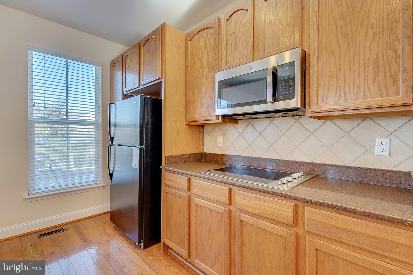 1010 Verdigris Way Odenton, MD 21113 - Photo 12 of 38 a kitchen with stainless steel appliances granite countertop white cabinets and a microwave oven