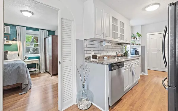 a kitchen with stainless steel appliances granite countertop a refrigerator a stove and a wooden floors