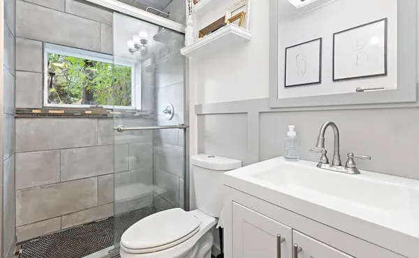 a bathroom with a sink a toilet and shower