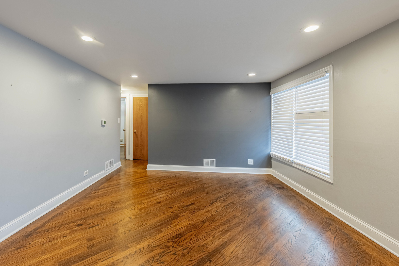 8912 South Ryan Road Hometown, IL 60456 - Photo 3 of 23 a view of an empty room with wooden floor and a window