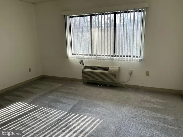 a view of a room with wooden floor and a window
