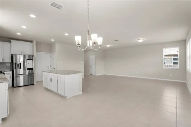 a large white kitchen with a large counter top stainless steel appliances and cabinets