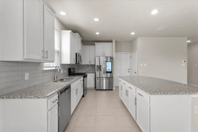 a kitchen with a sink appliances and cabinets