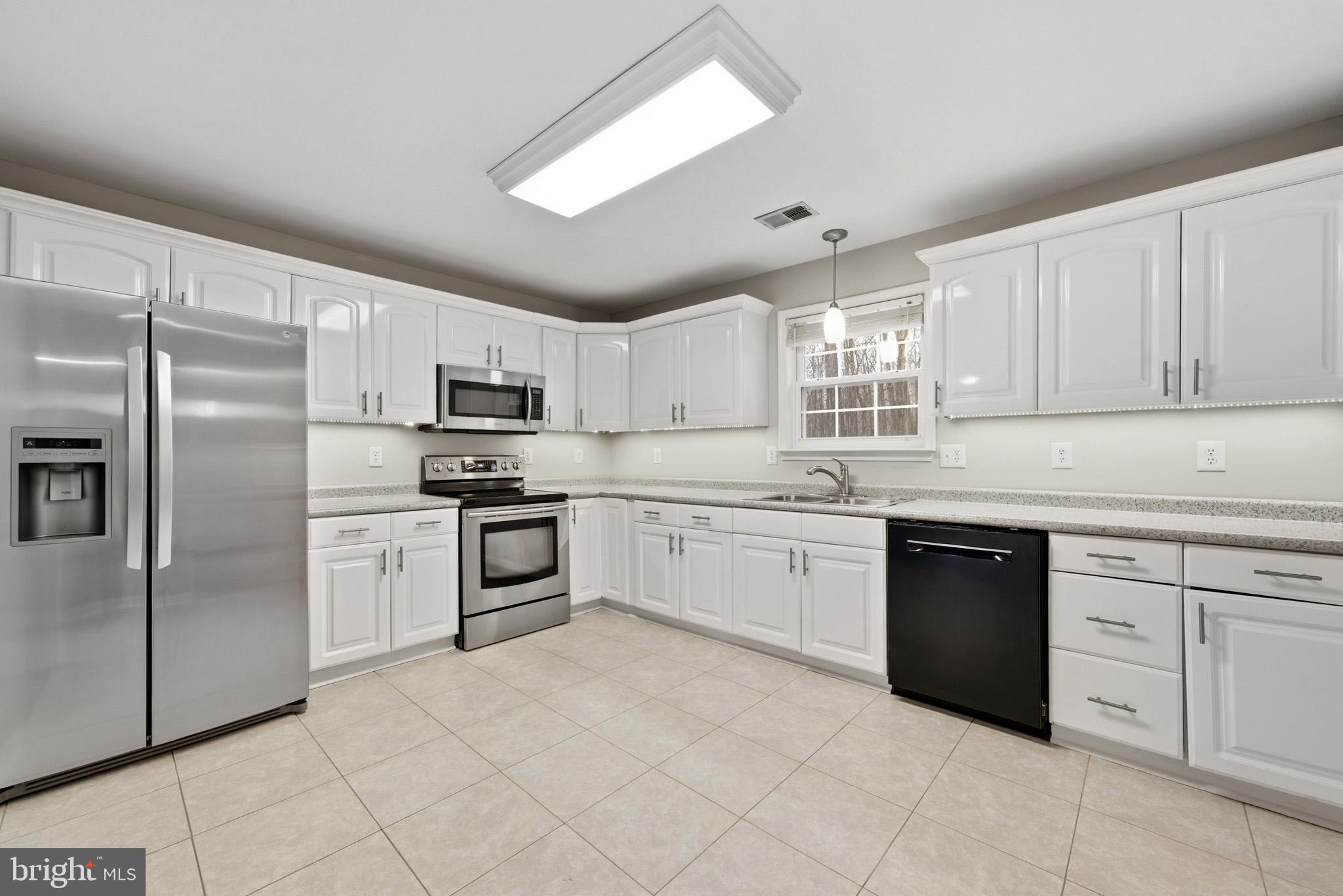 22343 Newtowne Neck Road Leonardtown, MD 20650 - Photo 12 of 40 a kitchen with granite countertop white cabinets and stainless steel appliances