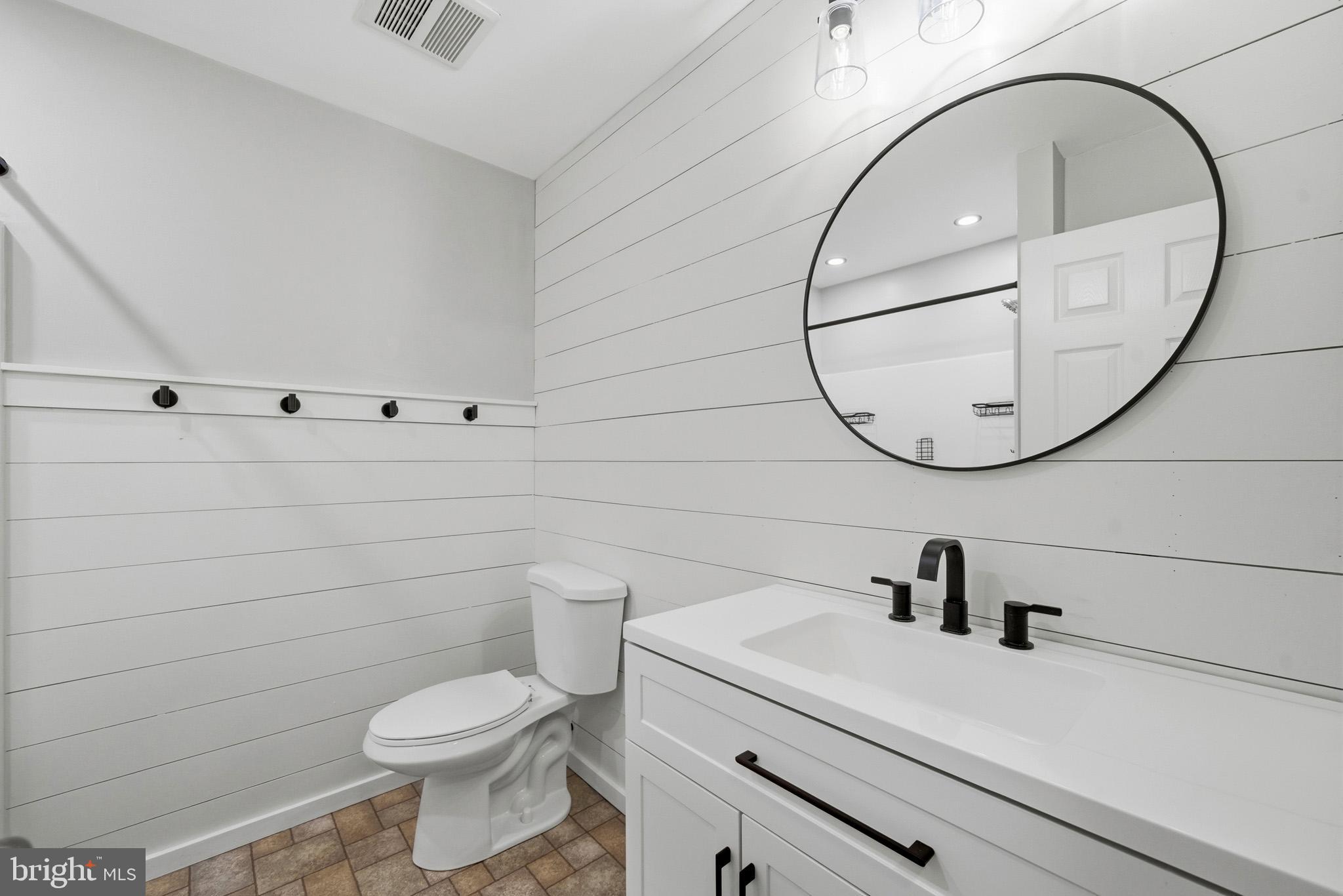 22343 Newtowne Neck Road Leonardtown, MD 20650 - Photo 31 of 40 a bathroom with a sink a toilet and a mirror