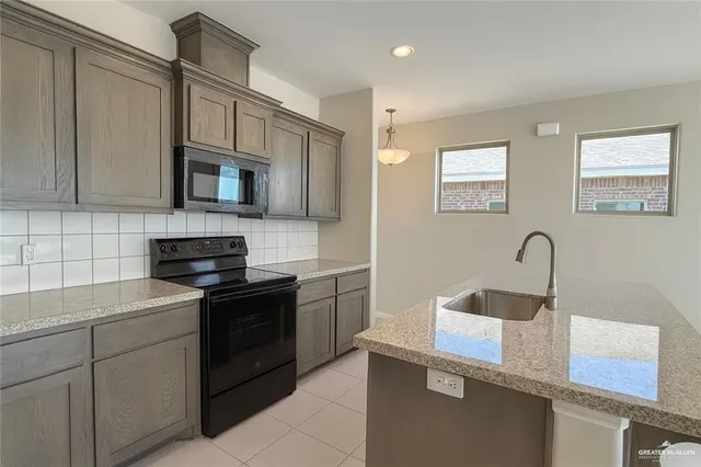 a kitchen with a sink and a stove top oven