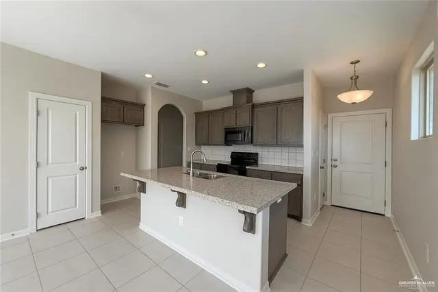 a kitchen with a sink a counter top space stainless steel appliances and cabinets