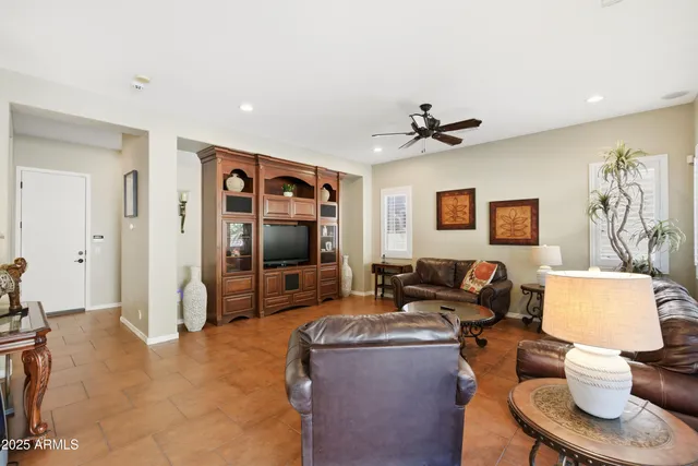 a view of a patio with couches and a table and chairs with wooden floor and fence