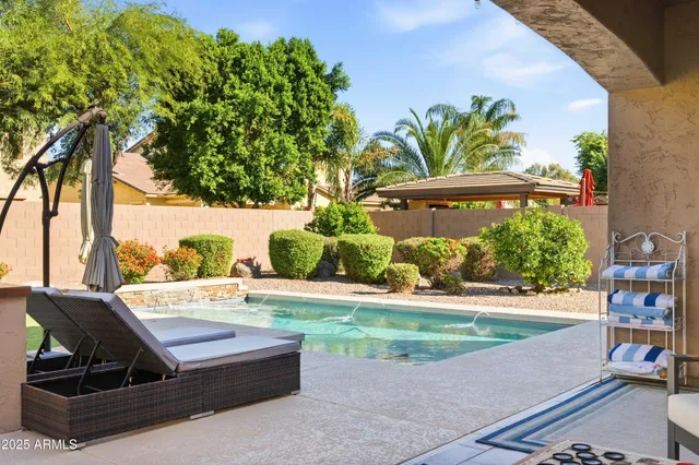 a view of a white house with a big yard and potted plants