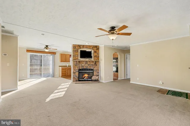 a view of an empty room with a fireplace and a window