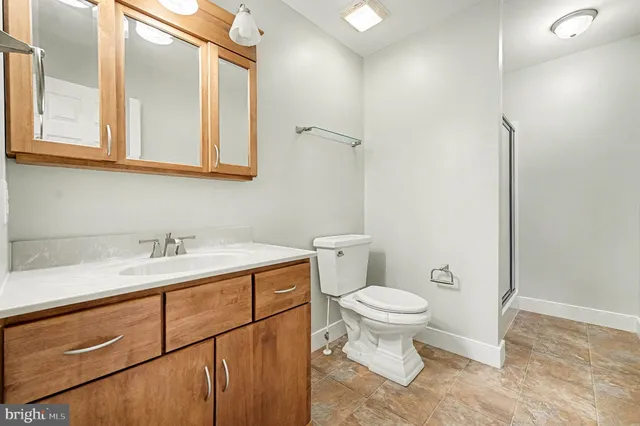 a bathroom with a granite countertop sink a toilet and a mirror