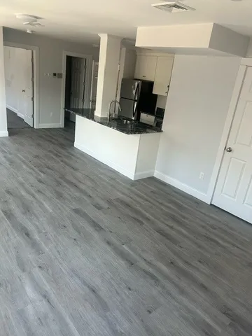 a view of a kitchen with wooden floor and electronic appliances