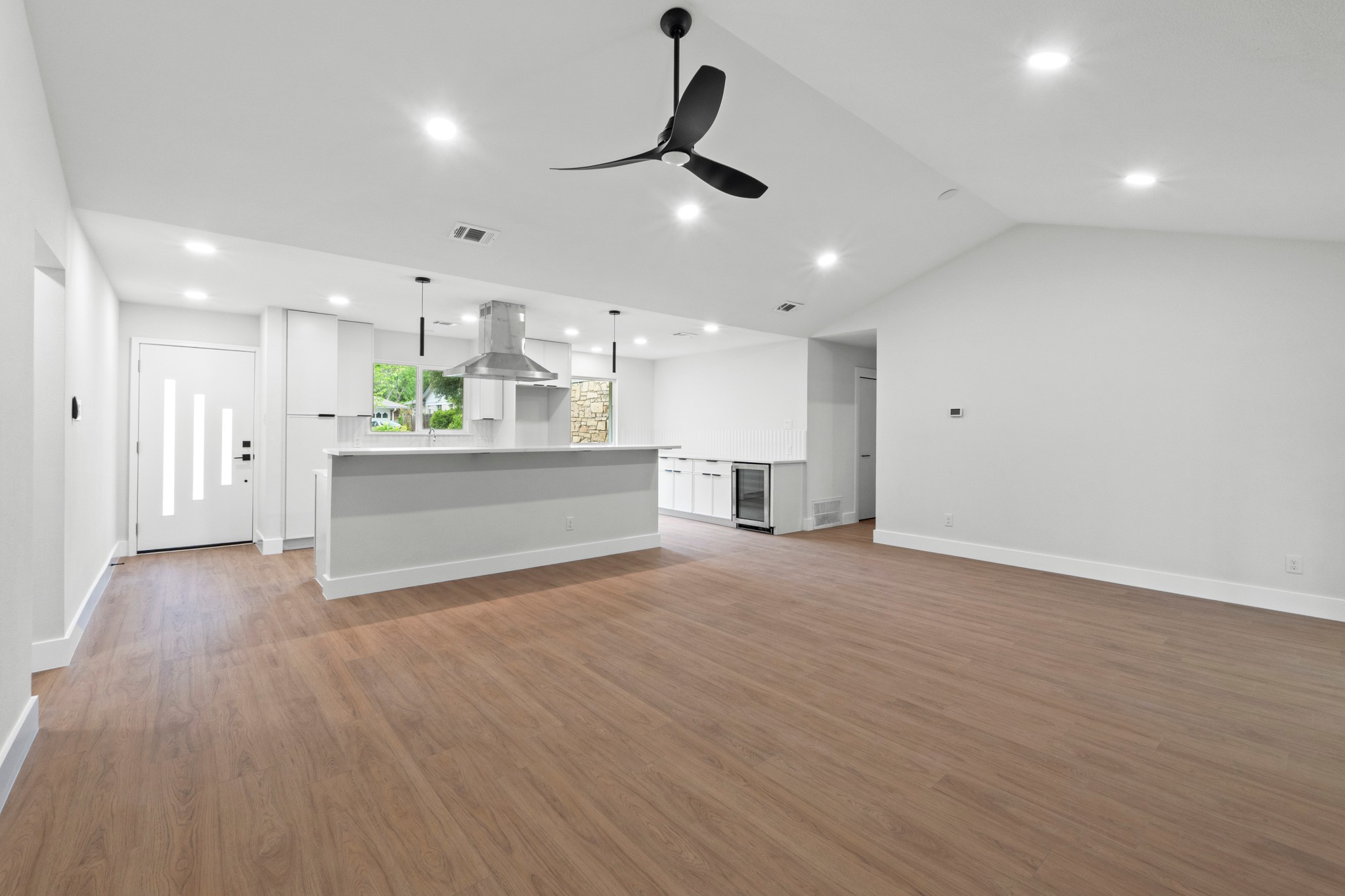1608 Springer Lane Austin, TX 78758 - Photo 23 of 35 Spacious open-concept living area featuring a vaulted ceiling and wood-finish flooring