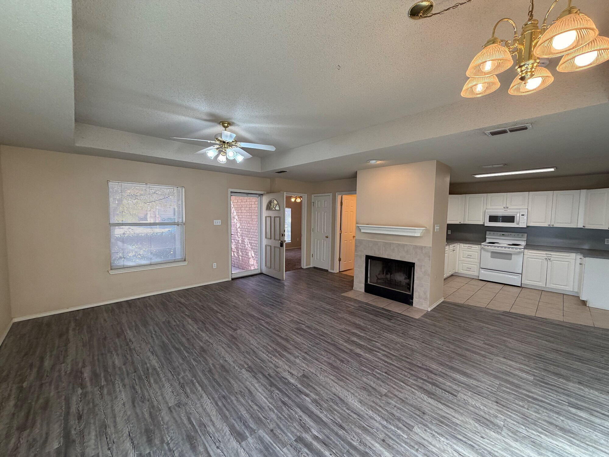 9713 Joliet Avenue Lubbock, TX 79423 - Photo 2 of 11 a view of a livingroom with a fireplace a ceiling fan and windows