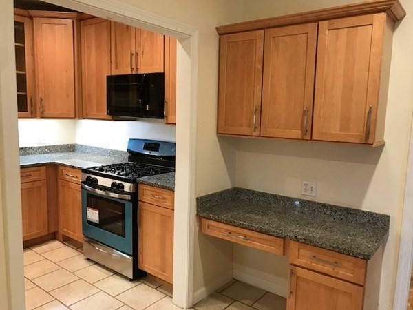 141 Jefferson Avenue, Unit 2 Everett, MA 02149 - Photo 3 of 10 a kitchen with granite countertop stainless steel appliances a stove a microwave and a sink