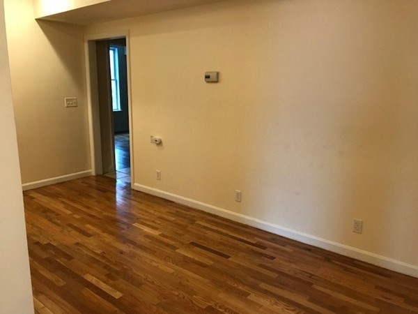 141 Jefferson Avenue, Unit 2 Everett, MA 02149 - Photo 9 of 10 a view of an empty room with wooden floor and a window