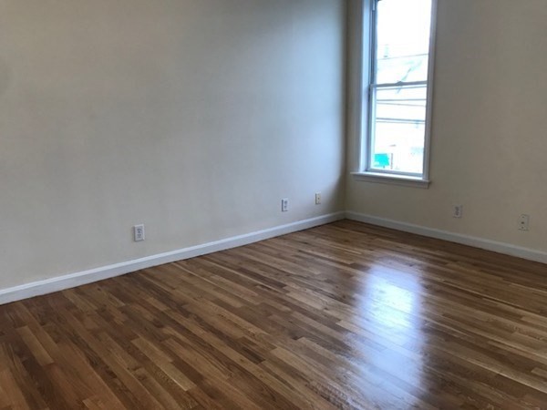 141 Jefferson Avenue, Unit 2 Everett, MA 02149 - Photo 10 of 10 an empty room with wooden floor and windows