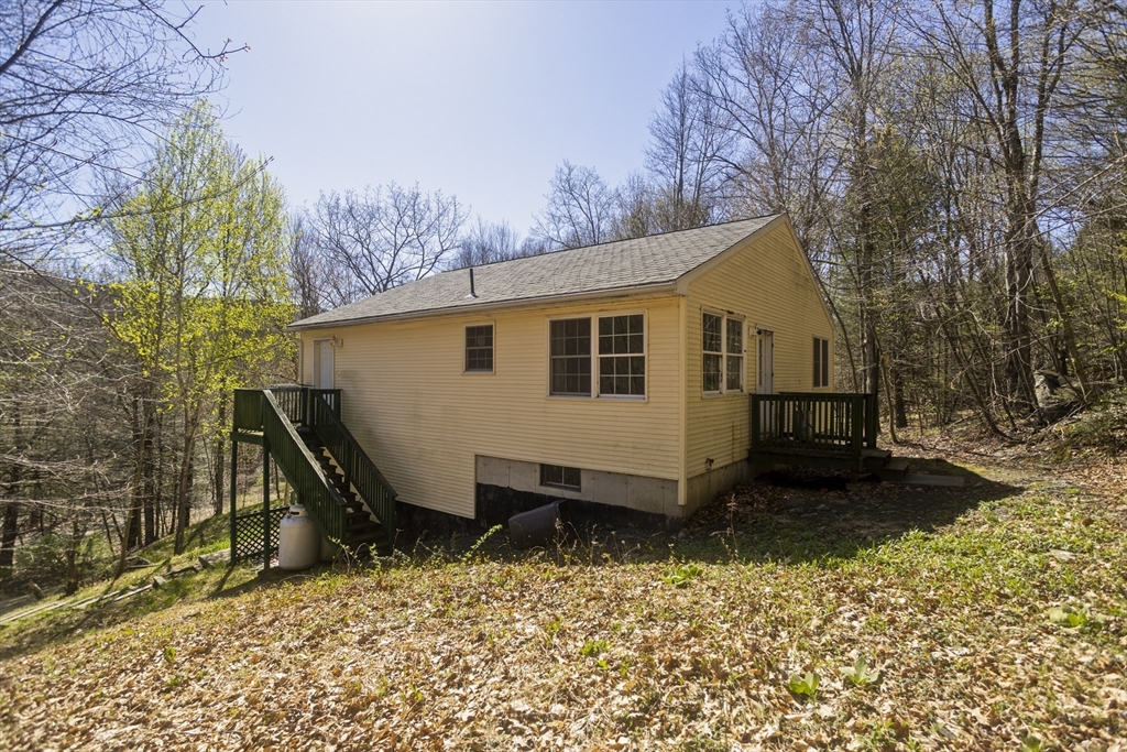 300 Middlefield Road Chester, MA 01011 - Photo 5 of 40 a view of a small house with backyard and sitting area