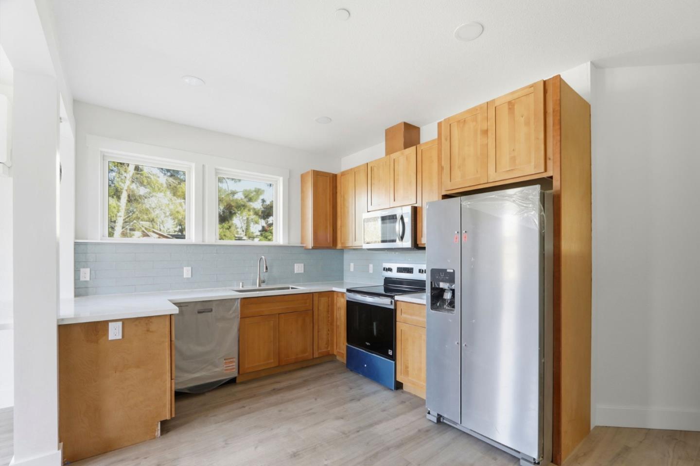 140 East Reed Street, Unit 3 San Jose, CA 95112 - Photo 4 of 8 a kitchen with stainless steel appliances granite countertop a refrigerator a sink and a stove