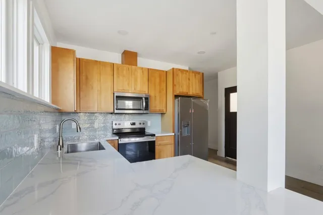 a kitchen with stainless steel appliances granite countertop a refrigerator stove and sink