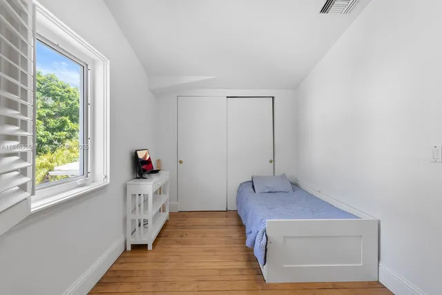 a hallway with wooden floor and windows
