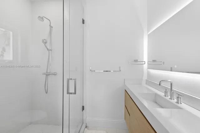 a bathroom with a granite countertop shower sink and mirror