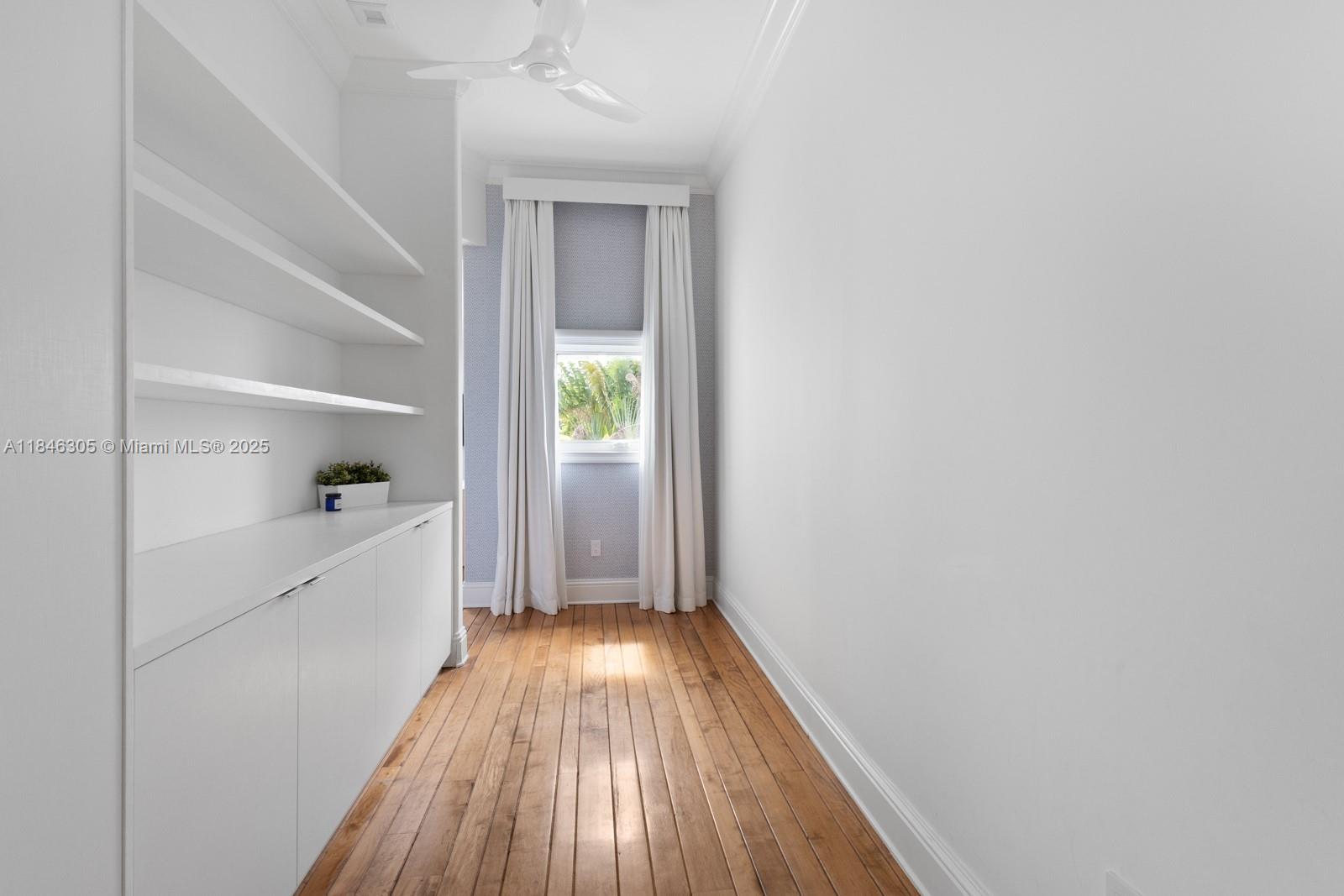 5 Coconut Lane Key Biscayne, FL 33149 - Photo 25 of 41 a hallway with white cabinets and wooden floor