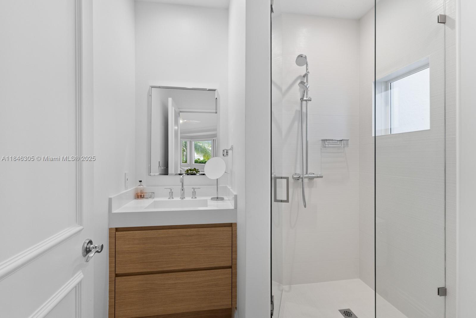 5 Coconut Lane Key Biscayne, FL 33149 - Photo 33 of 41 a bathroom with a shower sink vanity and mirror