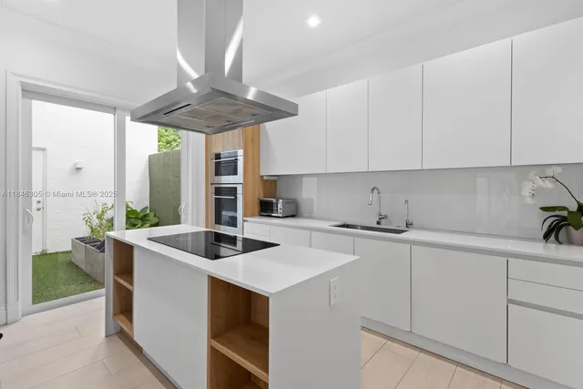 a kitchen with stainless steel appliances granite countertop a sink a stove and white cabinets