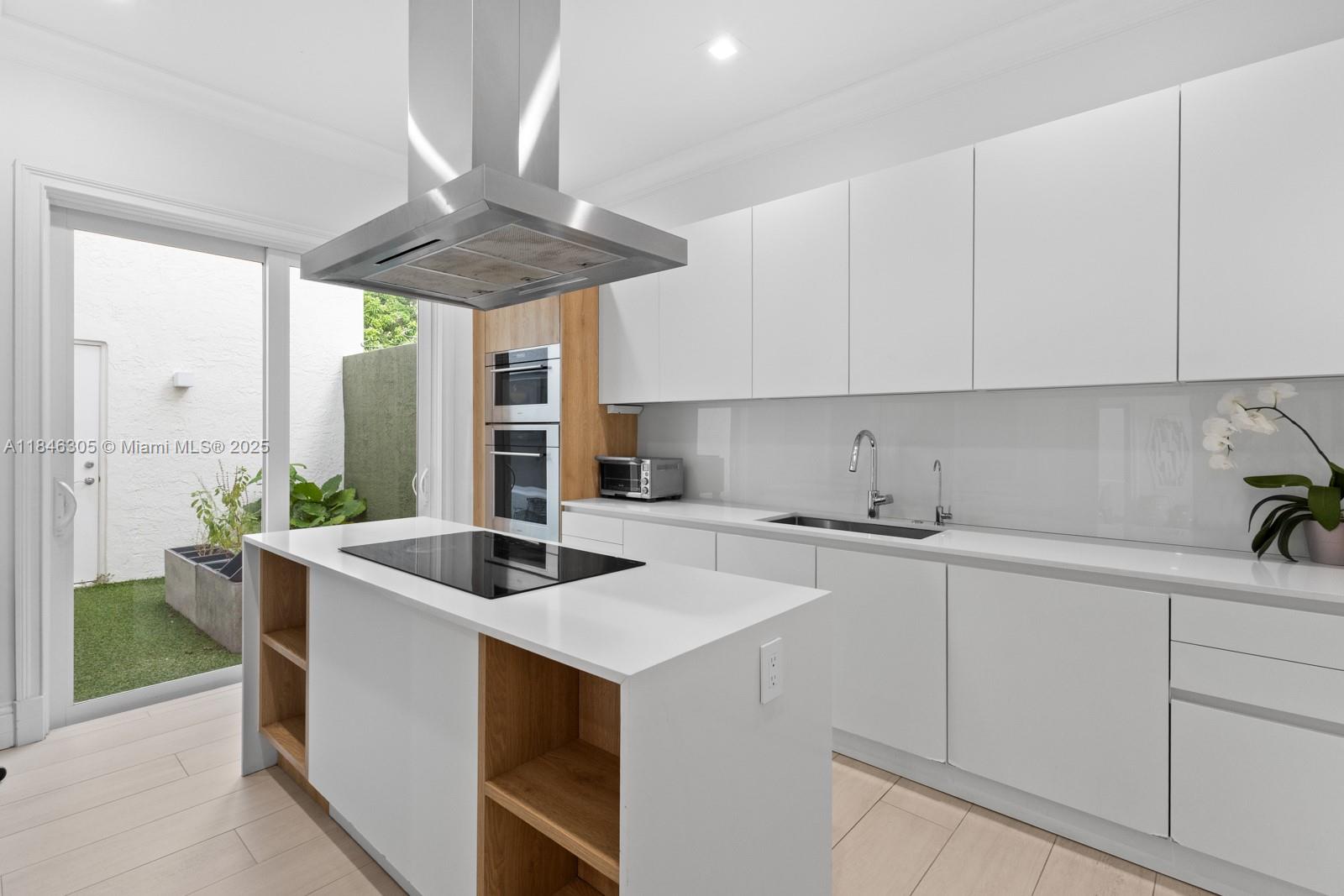 5 Coconut Lane Key Biscayne, FL 33149 - Photo 6 of 41 a kitchen with stainless steel appliances granite countertop a sink a stove and white cabinets
