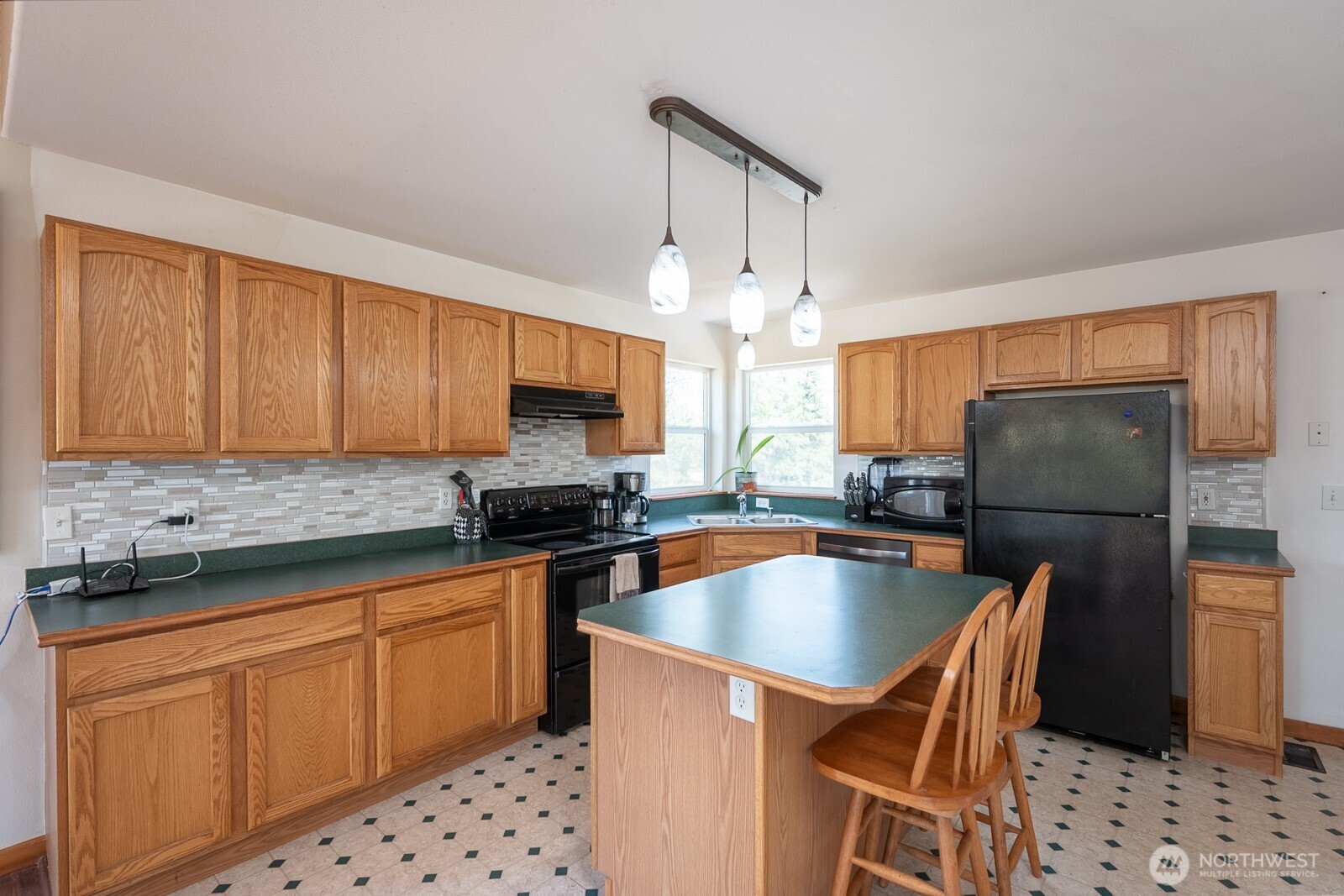 2207 West Depot Springs Road Spangle, WA 99031 - Photo 9 of 26 a kitchen with stainless steel appliances a sink a stove a refrigerator cabinets and dining table