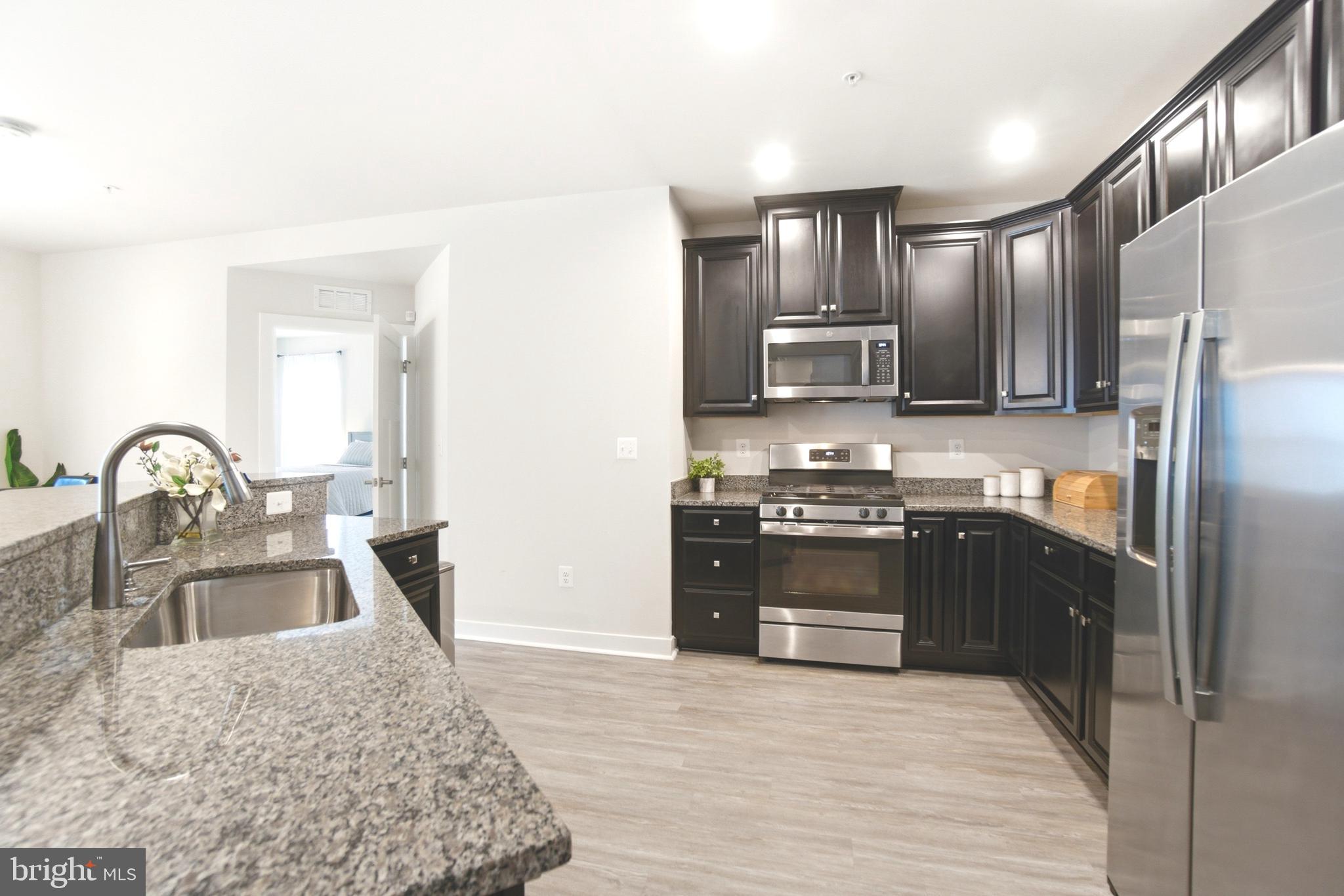 10020 Ruffian Way, Unit A Laurel, MD 20723 - Photo 11 of 36 a kitchen with granite countertop a refrigerator stove top oven and sink
