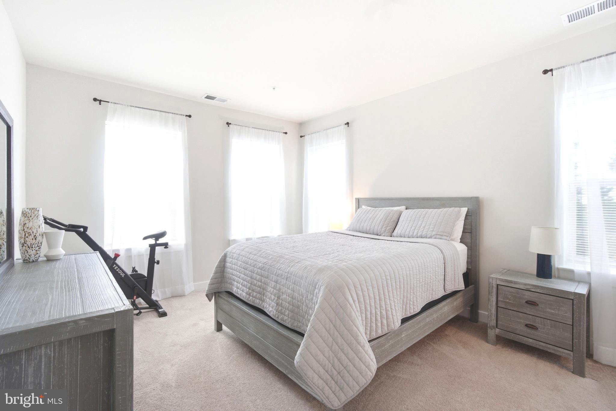 10020 Ruffian Way, Unit A Laurel, MD 20723 - Photo 12 of 36 a bedroom with a bed and a flat tv screen on dresser