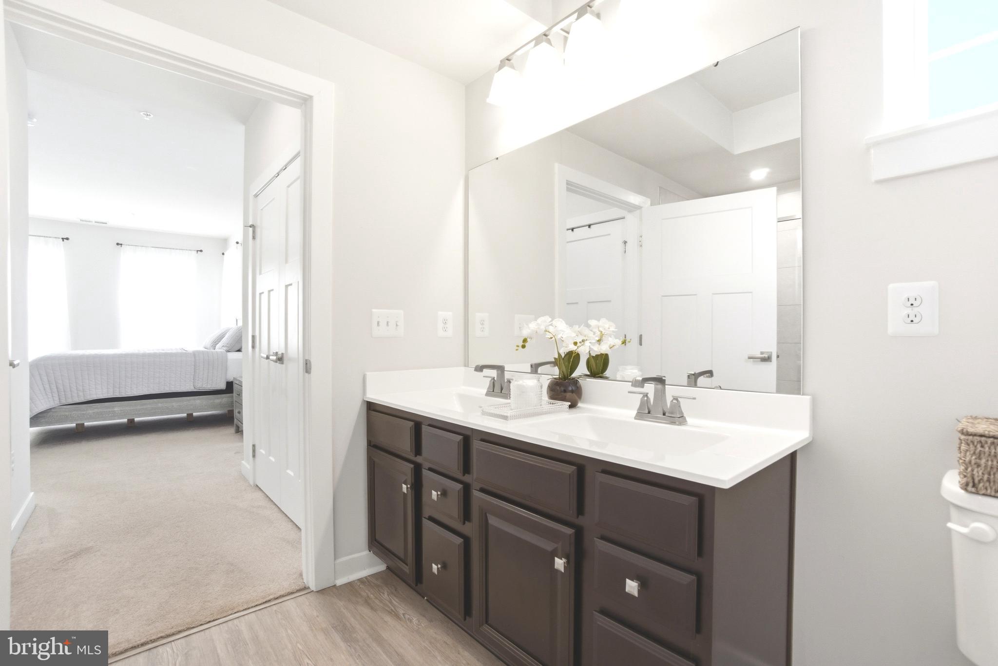 10020 Ruffian Way, Unit A Laurel, MD 20723 - Photo 16 of 36 a en suite bathroom with a sink a mirror and a bathtub