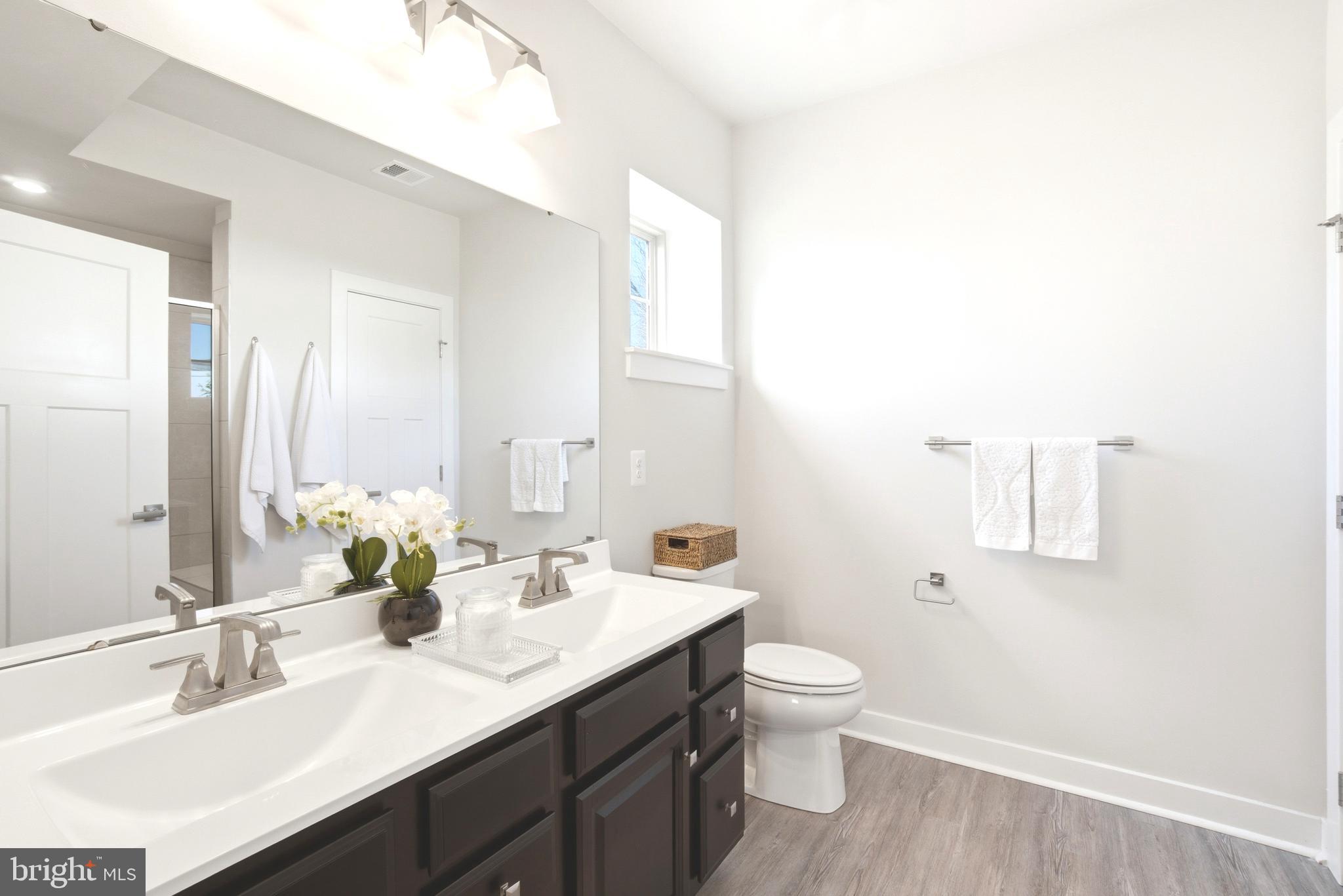 10020 Ruffian Way, Unit A Laurel, MD 20723 - Photo 17 of 36 a bathroom with a double vanity sink toilet and mirror