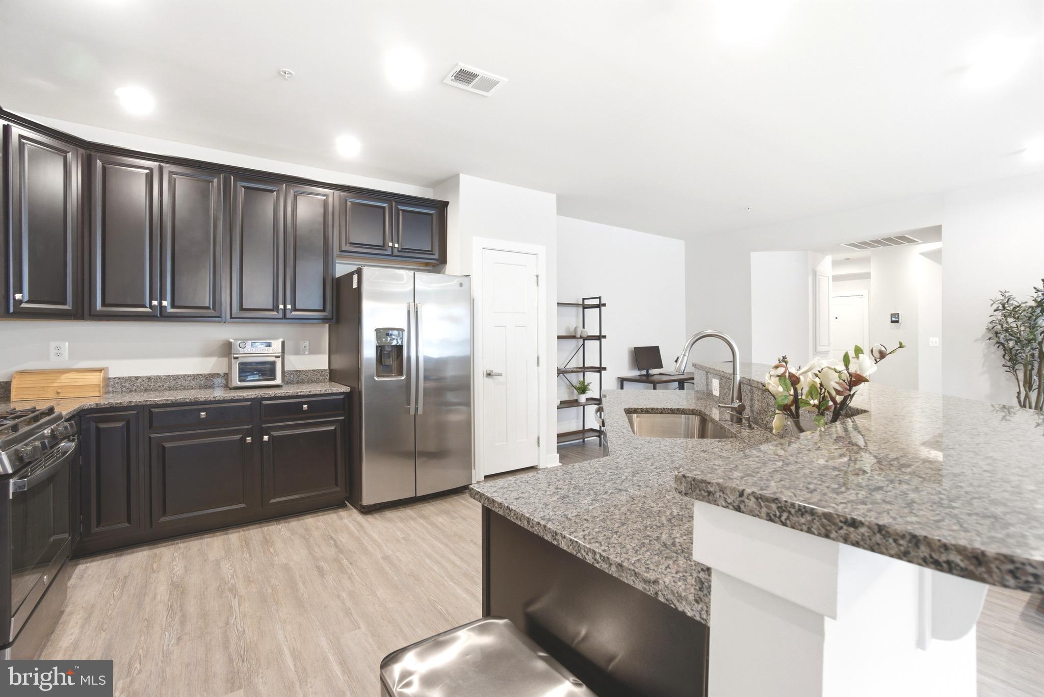 10020 Ruffian Way, Unit A Laurel, MD 20723 - Photo 6 of 36 a kitchen with stainless steel appliances granite countertop a sink refrigerator and cabinets