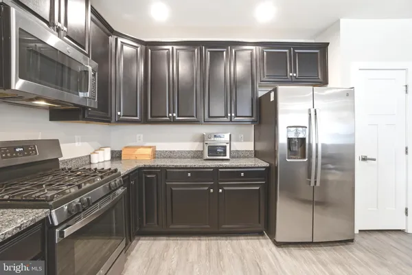 a kitchen with stainless steel appliances granite countertop a stove a refrigerator and a sink