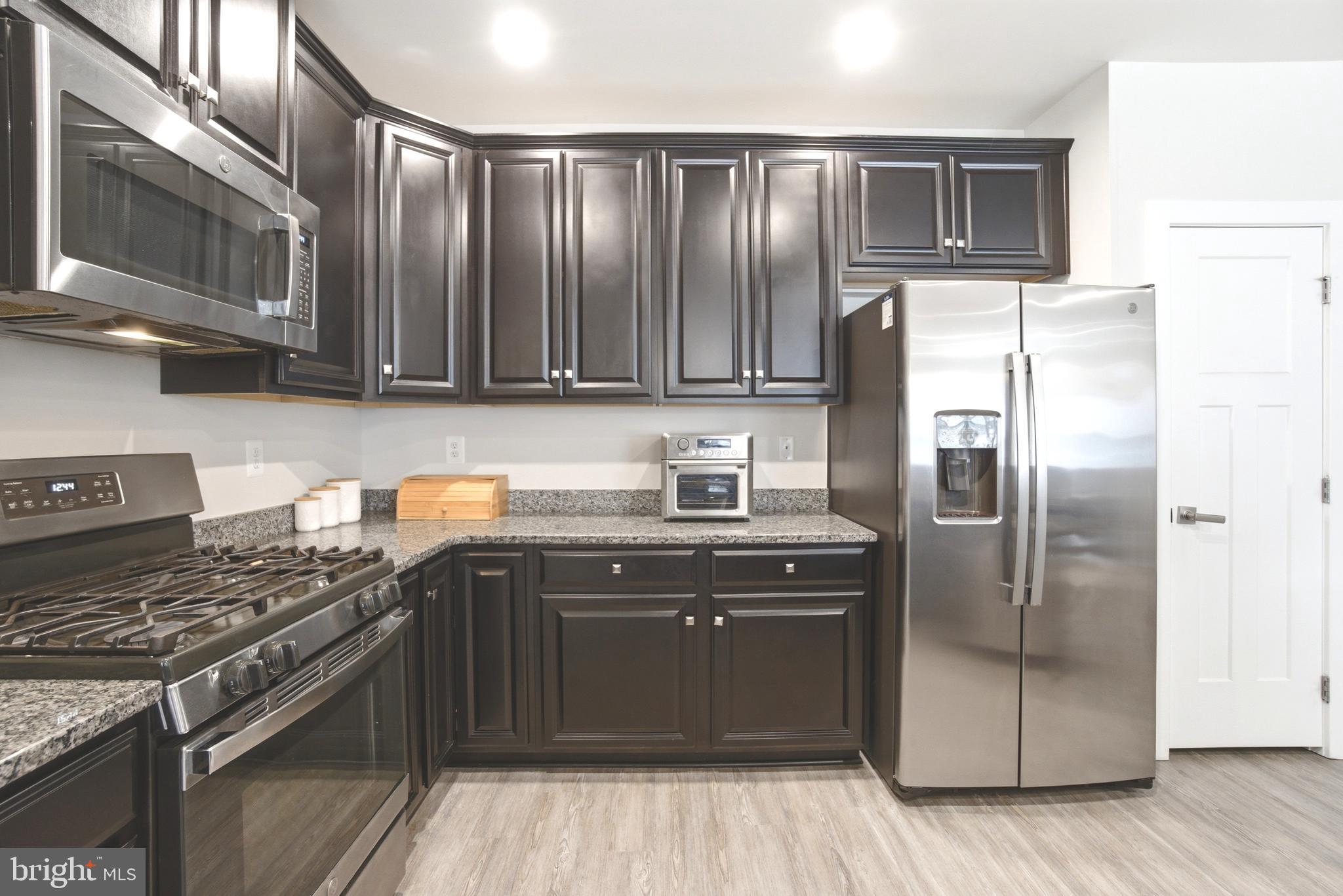 10020 Ruffian Way, Unit A Laurel, MD 20723 - Photo 8 of 36 a kitchen with stainless steel appliances granite countertop a stove a refrigerator and a sink