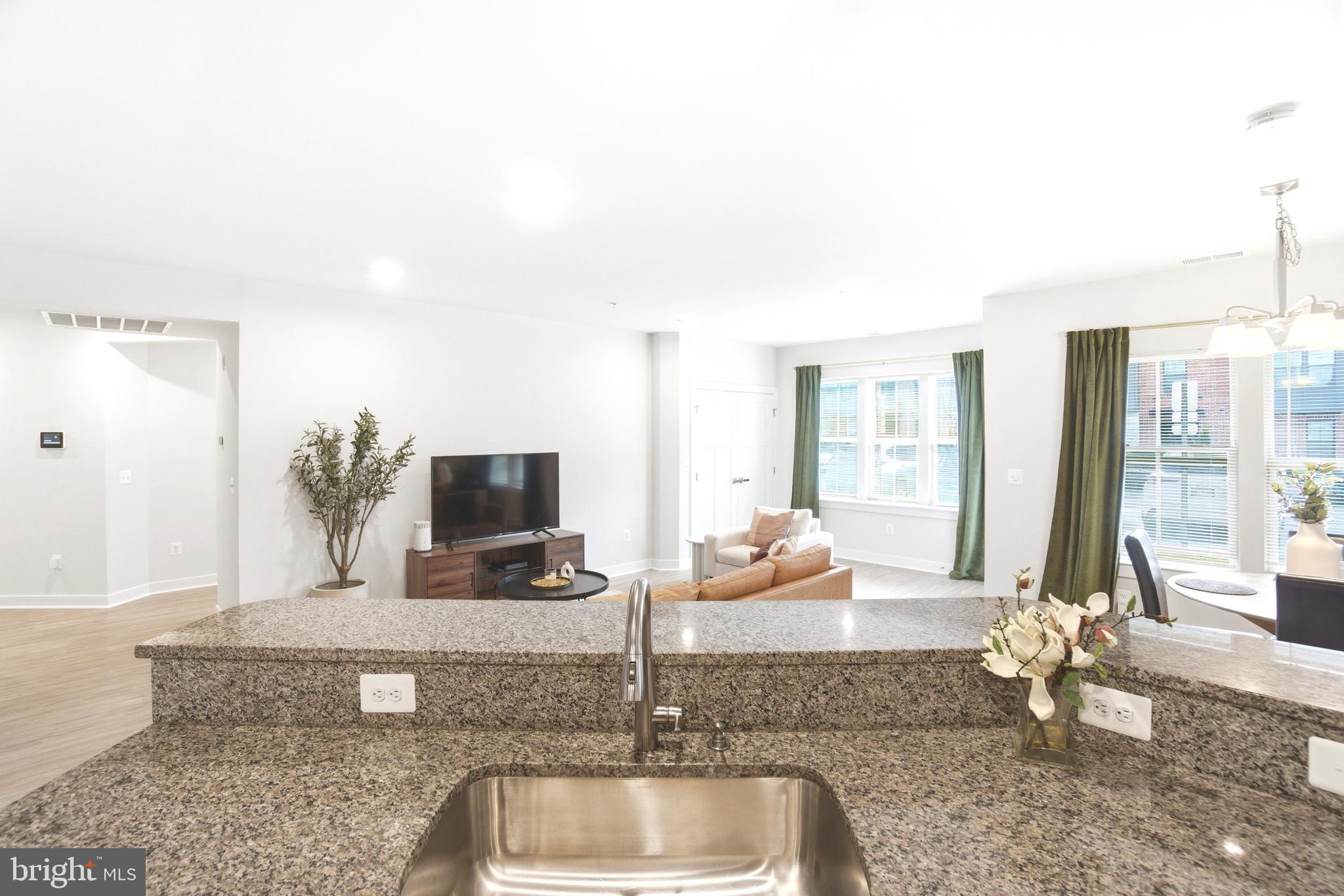 10020 Ruffian Way, Unit A Laurel, MD 20723 - Photo 10 of 36 a living room with granite countertop a couch and a flat screen tv