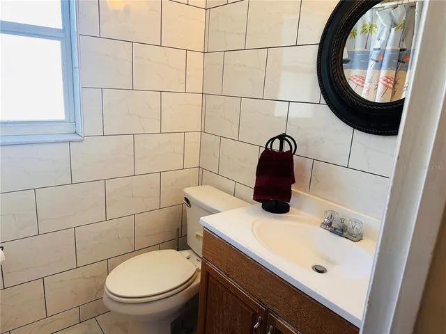 a bedroom with a bed and dresser with mirror